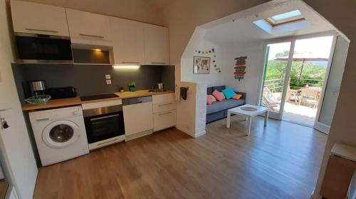 eine Küche und ein Wohnzimmer mit Waschmaschine und Trockner in der Unterkunft la Casa del Sol -2 à 5 pers - 5km de Saint Tropez in Gassin