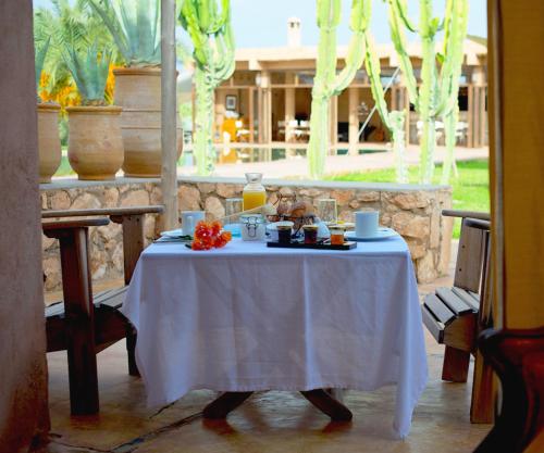 una mesa con un mantel blanco. en La Parenthese de Marrakech en Tameslouht