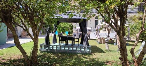 a gazebo with a table and chairs in a yard at Castle By The Sea in Artemida