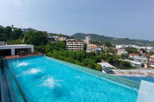 a large blue swimming pool on top of a building at Triple L Hotel Patong Beach Phuket in Patong Beach