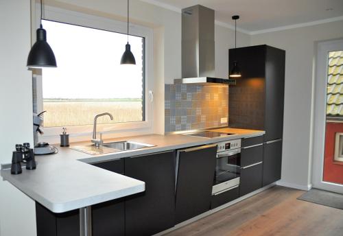费马恩Albertsdorf Goldblick的厨房配有黑色橱柜、水槽和窗户