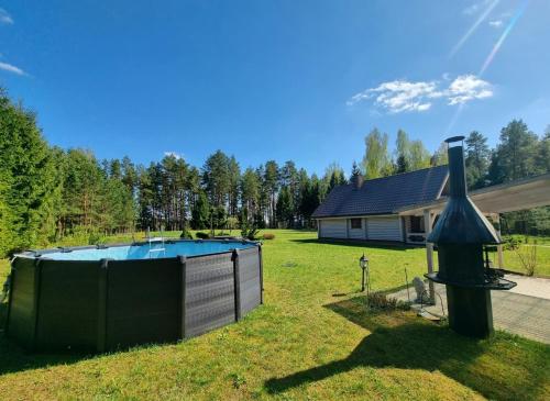 a backyard with a swimming pool and a house at Beautiful Villa For Family/Couples in Molėtai
