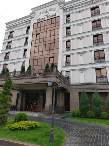 a large white building with a courtyard in front of it at Plaza Hotel Almaty in Almaty