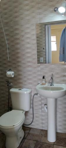 La salle de bains est pourvue de toilettes et d'un lavabo. dans l'établissement Kitnet Marília, à Marília