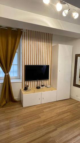 un salon avec une télévision à écran plat sur un meuble blanc dans l'établissement Joli studio Avignon intra-muros, à Avignon