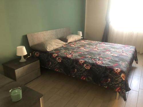 1 Schlafzimmer mit einem Bett mit Blumenbettdecke in der Unterkunft Appartamento Veronica, per lavoro e relax in Corsico