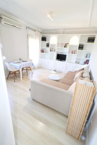 - un salon blanc avec un grand lit et une table dans l'établissement Apartamento Boutique, à Cenes de la Vega