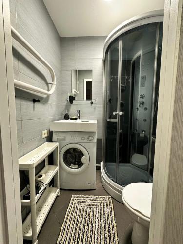 łazienka z pralką i prysznicem w obiekcie Sea side apartments w Jurmale