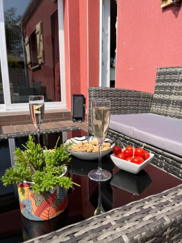 a table with two glasses of wine and a plate of food at - NEW - La TerraCalm - WiFi / Netflix in Cherbourg en Cotentin
