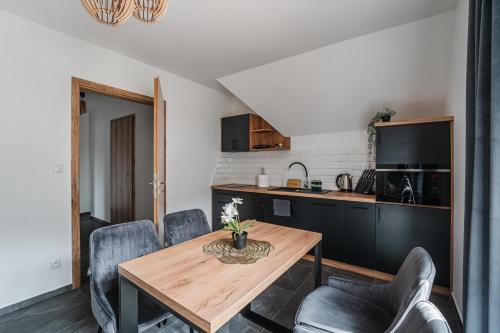 a kitchen and dining room with a wooden table and chairs at Osada turystyczna Malinów in Szczawnica