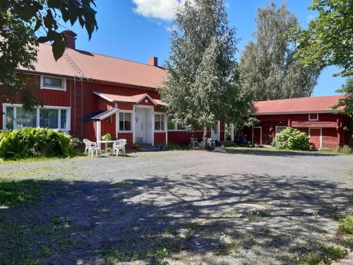 un edificio rojo con un árbol delante de él en Tilava huoneisto puutarhanäkymällä en Kankaanpää