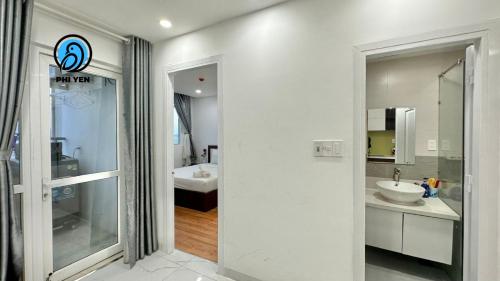 a white bathroom with a sink and a mirror at Phi Yen Muong Thanh 04 Apartment in Nha Trang