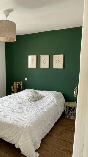 - une chambre avec un mur vert et un lit dans l'établissement Magnifique villa avec piscine et cabane, à Saubrigues