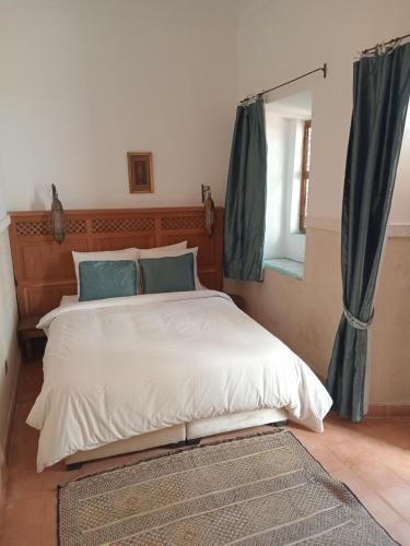 1 dormitorio con 1 cama grande y espejo en Riad le Jardin de Mina, en Marrakech