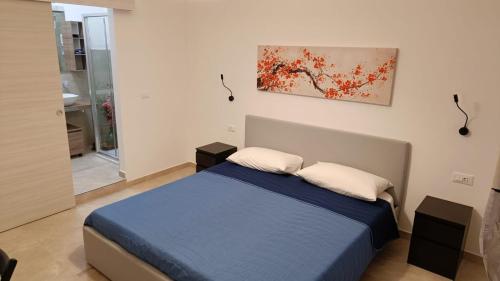 een slaapkamer met een bed en een schilderij aan de muur bij Neapolis Apartment & Rooms in Siracusa