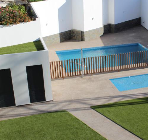 a swimming pool next to a building with grass at Apartamento Flow Living, com piscina, em Olhão in Olhão