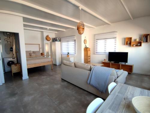 a living room with a couch and a tv at Ático en Las Canteras in Las Palmas de Gran Canaria