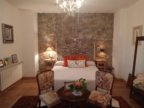 a bedroom with a bed and a table and chairs at Palacio de Arredondo in Gama