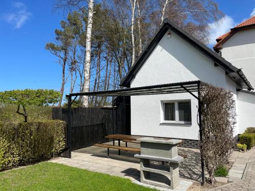 a house with a picnic table and a bench at Villa & Domek Maja in Sarbinowo