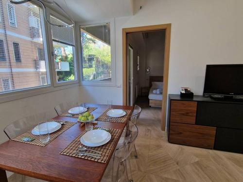 a dining room with a table and a television at Casa Camilla in Rome