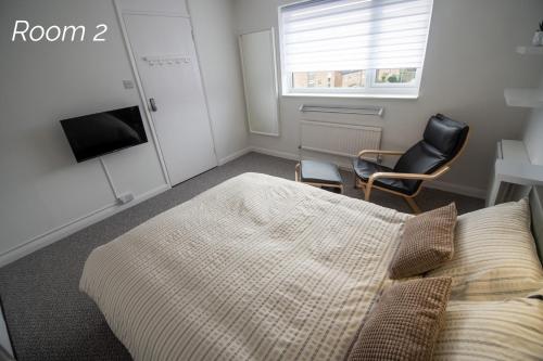 a bedroom with a bed and a chair and a window at Town House Chantry - With Self Check In and Free Parking - Rooms at ipswichdigs in Ipswich
