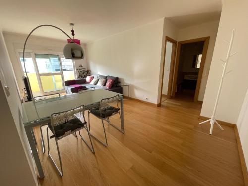 uma sala de estar com uma mesa de vidro e cadeiras em Lisbon Spirit (with free parking) em Lisboa