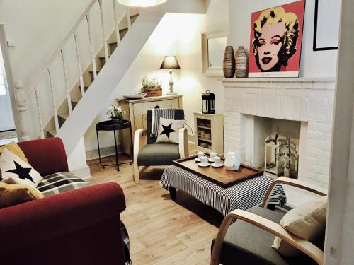 uma sala de estar com lareira e uma escada em Delightful Seaside Binnacle Cottage -hosted by Whitstable-Holidays em Whitstable