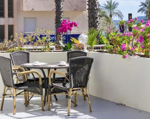 d'une table et de chaises sur un balcon fleuri dans l'établissement Anglade Hotel, au Lavandou
