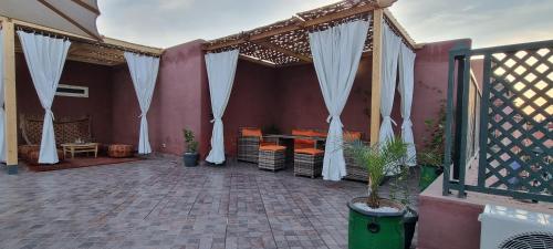 a patio with white curtains and a table and chairs at Marrakech medina inn in Marrakesh
