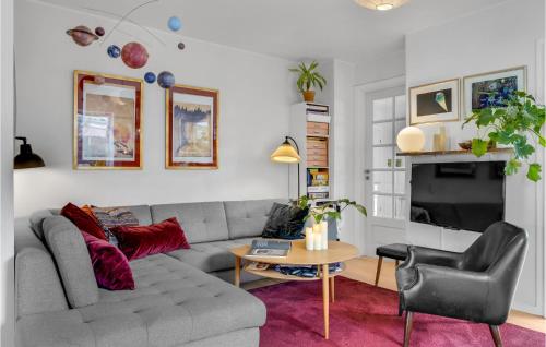a living room with a gray couch and a table at Gorgeous Home In Kbenhavn S With Kitchen in Copenhagen