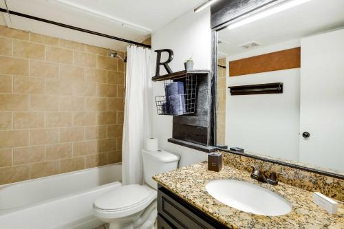 a bathroom with a sink and a toilet and a tub at Contemporary Dallas Condo with Pool Access! in Dallas