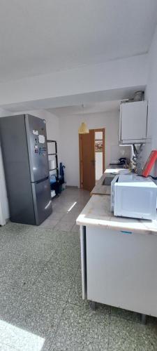 a kitchen with a refrigerator and a counter in a room at Guest House Casa Ramos on the Strip in Albufeira