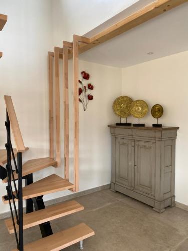 a staircase in a room with a cabinet and flowers at Charmant chalet, spacieux, proche du lac, vue sur la montagne in Gérardmer