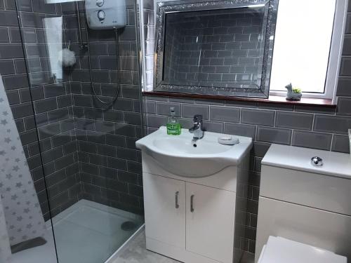 y baño con lavabo y ducha. en Lovely 3 bedroom apartment in Buncrana, en Buncrana