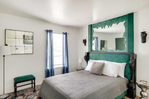 1 dormitorio con 1 cama con cabecero verde y espejo en Chic Dallas Vacation Rental Pool, Walk to Knox St en Dallas
