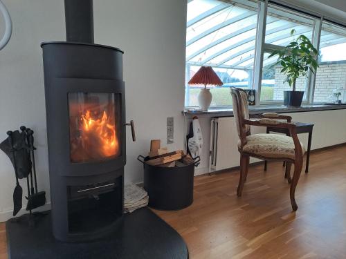 a fireplace in a living room with a chair and a table at VindPust in Varde