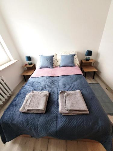 a bedroom with a bed with two towels on it at Apartament Ślęczka in Zabrze