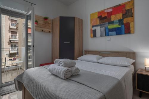 um quarto com 2 camas e toalhas em Mamo Thessaloniki Studios em Tessalônica