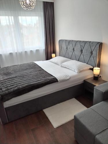 a bedroom with a large bed and a couch at Apartman 007 in Kragujevac