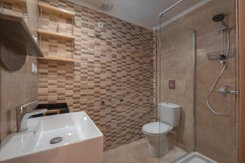uma casa de banho com um WC, um lavatório e um chuveiro em Mamo Thessaloniki Studios em Tessalônica