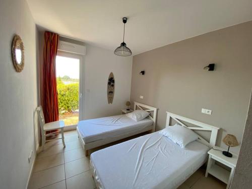 une chambre d'hôtel avec deux lits et une fenêtre dans l'établissement Ma paillote a LOZARI 6/8 pers vue mer avec piscine, à Palasca