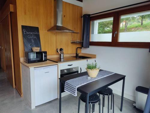 a small kitchen with a table and a microwave at Apartamento nuevo con vistas a las Islas Cíes in Cangas de Morrazo