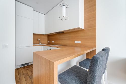 a kitchen with a wooden table and two chairs at KALVARI APARTMENTs in Vilnius
