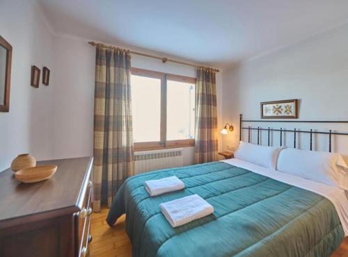 a bedroom with a large bed and a window at Casa l'Avet. El Vilar d'Urtx in Escardacs