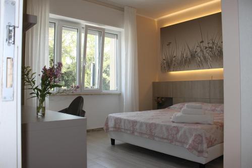 a bedroom with a bed and a desk and windows at La Terrazza sul mare in Otranto