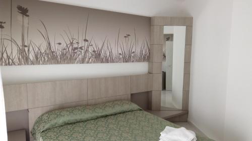 a bedroom with a bed with a wall with plants at La Terrazza sul mare in Otranto