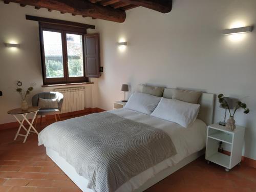 a bedroom with a large white bed and a window at Poggio ai Gelsi in Pienza