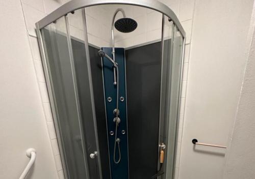 une douche avec une porte vitrée dans une salle de bain dans l'établissement Le Megevand, à Besançon