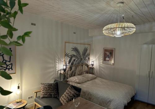 - une chambre avec un lit, un canapé et un lustre dans l'établissement Le Megevand, à Besançon