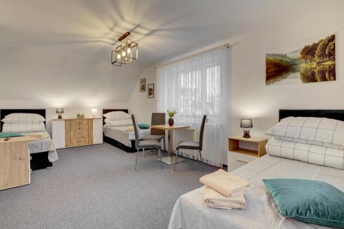 um quarto com duas camas e uma mesa em Apartament na wzgórzu em Muszyna